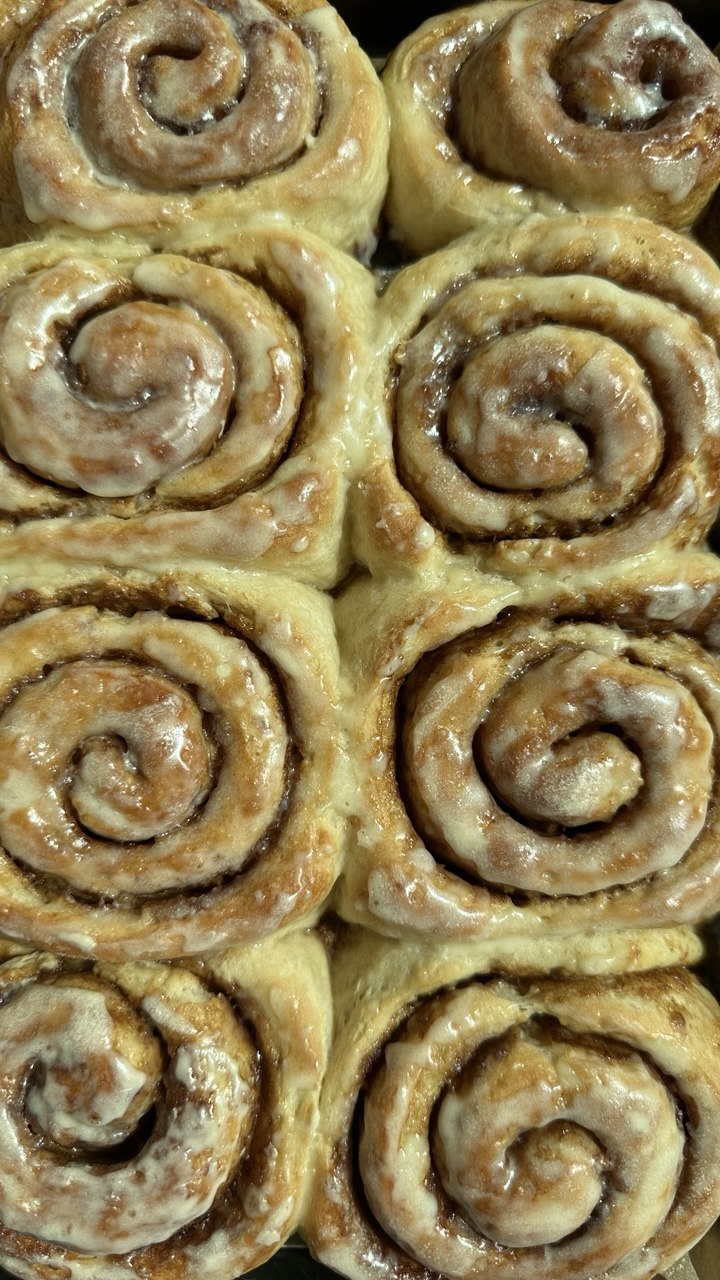 A box of glazed cinnamon buns prepared for sharing
